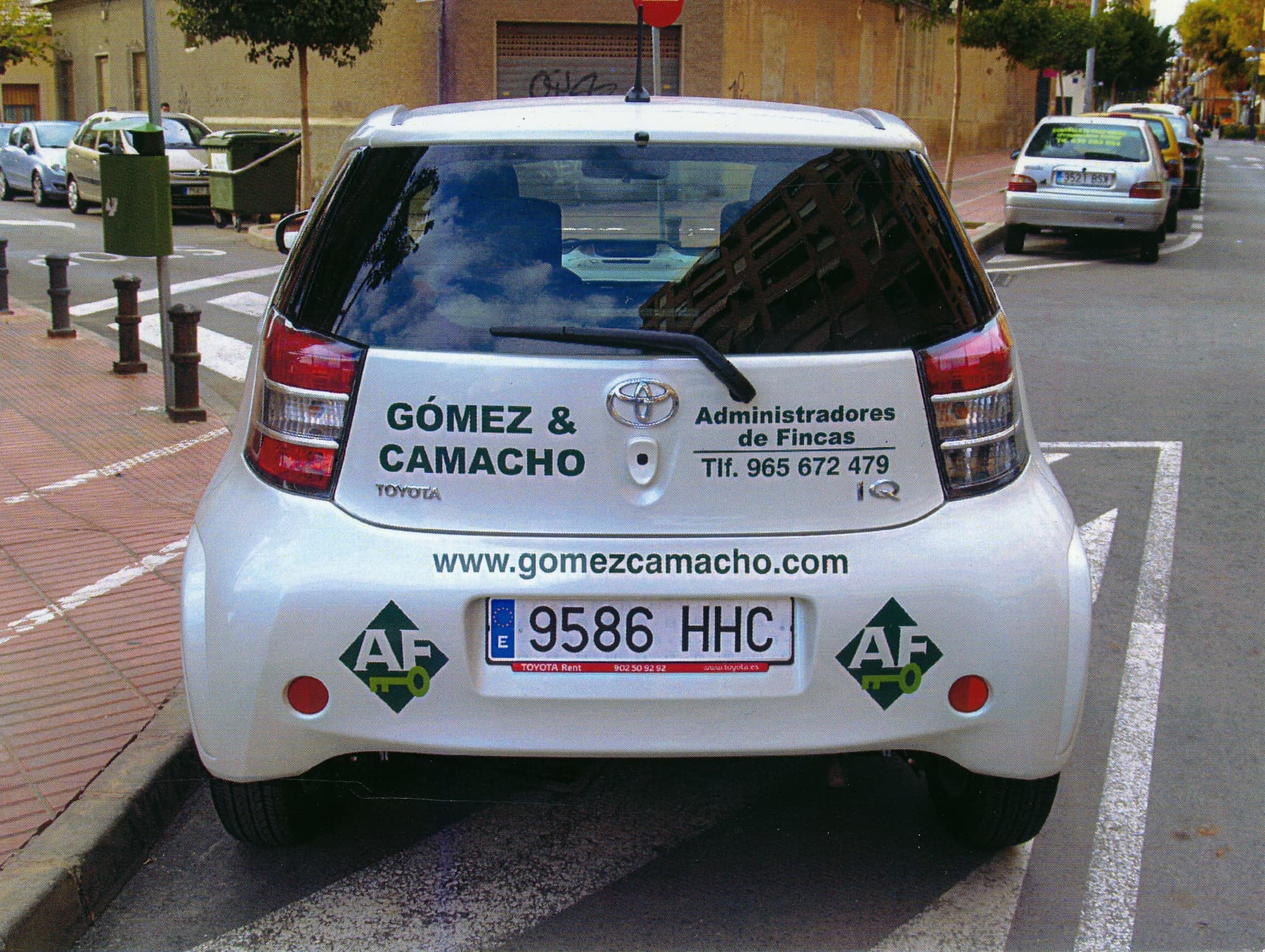 Coche urbano rotulado con los datos de contacto de Gómez & Camacho