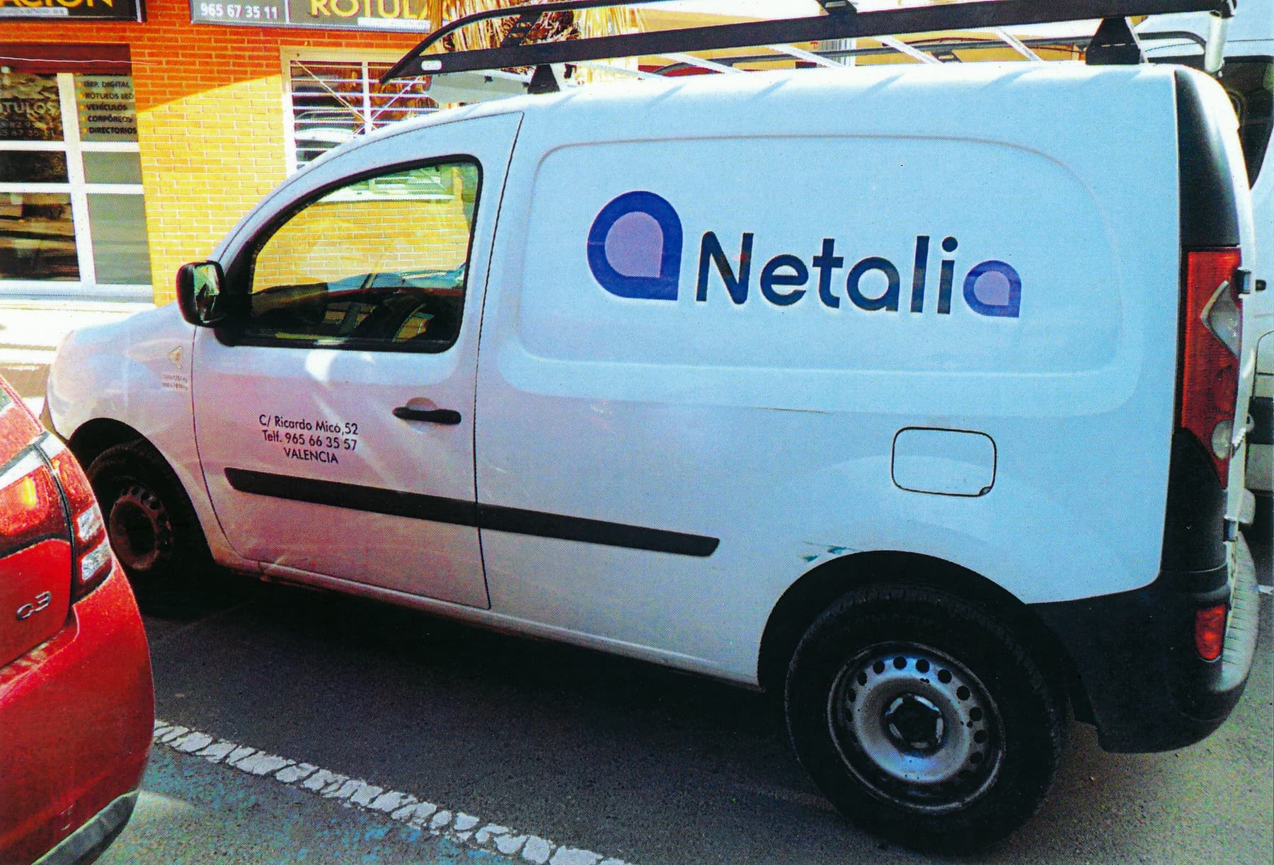Furgoneta blanca de Netalia con logotipo en vinilo de corte azul